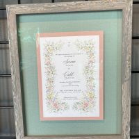 Framed wedding invitation Wedding invitation framed with a green mat and a rustic wood frame