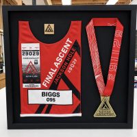 Race bib and medal shadowbox Race bib and finisher medal mounted together in a black shadowbox