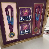 Race medals and bibs shadowbox Race medals and bibs arranged in a custom shadowbox frame